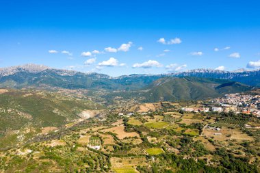 Sardinya 'da, Orgosolo' nun eteklerindeki açık mavi gökyüzünün altında uzanan engebeli zeytin korulukları ve engebeli zeytin ağaçlarının engin hava manzarası..
