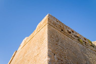 Yunanistan 'ın Nafplio kentindeki Palamidi Kalesi' nin açısal taş duvarlarının çarpıcı yükselişi, canlı mavi bir gökyüzüne karşı kuruluyor. Güneş ışığıyla aydınlanan taş ustası, heybetli geometri ve dokulu yüzeyleri vurguluyor..