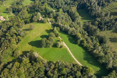 İnsansız hava aracı perspektifi, İtalya 'nın Val dAoste kentindeki sık ormanlık ve dağınık kırsal evlerle çevrili yemyeşil çayırlar ortaya çıkardı. Manzarada dolambaçlı yollar, açık otlak alanlar ve yaz sonlarında sakin bir kırsal atmosfer yer alıyor..