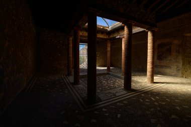 İtalya 'nın Pompeii kentindeki Menander Hanesi' nin açık tavan penceresinden gölgeli bir Roma avlusu ve merkezi bir örtüsü aydınlatılıyor. Mozaik döşemeler ve desenli taş duvarlar bunun tarihsel karakterini çağrıştırıyor