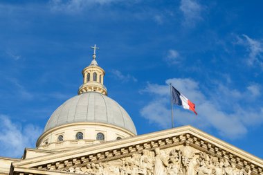 Paris 'teki Pantheon kubbesine yakın çekim. Üzerinde Fransız bayrağı dalgalanıyordu. Süslü, mavi bulutlu, canlı bir gökyüzüne karşı dizilmişti..