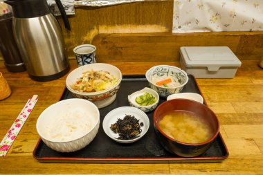 Japon kahvaltı tabakları pirinç, miso çorbası, turşu, haşlanmış sebzeler ve deniz yosunu sıcak ışık altında Kyoto 'nun kırsal bir restoranında servis edilir..