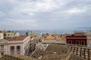 Cagliaris 'in çeşitli Pastel ve Terracotta çatıları gözümüzü şehir limanına ve bulutlu bir gökyüzünün altında ufka bakan uzak dağlarla Akdeniz' e çevirdi..