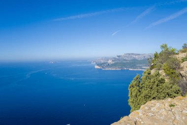 Parlak güneş ışığı Akdeniz kıyılarını sarp kayalıklarla ve Cassis yakınlarındaki derin mavi sulara bakan yemyeşil sularla aydınlatır. Sahne açıklık, canlı bir renk ve doğal bir sükunet içeriyor..