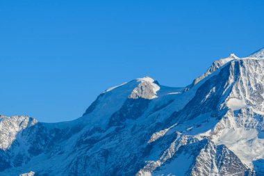 Kış ışığı, Mont Blanc du Tacul 'un karla kaplı yamaçlarını ve engebeli hatlarını gözler önüne seriyor..