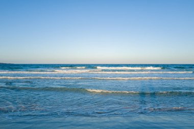 San Teodoro, Sardunya 'nın sığ kıyılarında hafif dalgaların dalgalanması, Akdeniz' in yumuşak gün ışığında bulutsuz bir gökyüzüyle karşılaşması..