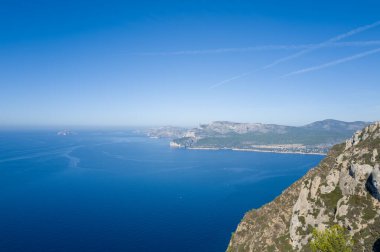 Cassis yakınlarındaki engebeli kireçtaşı kayalıkları ve derin gök mavisi Akdeniz 'in yüksek görüş açısı, uzak kıyı şeridi ve açık mavi gökyüzünün altındaki dağlar. Sahne uçsuz bucaksızlığı, sükuneti ve doğal güzelliği yansıtıyor..