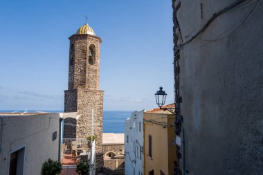 Sardunya 'nın Castelsardo kentindeki mavi Akdeniz manzaralı, beyazlatılmış ve yağlı binaların üzerinde renkli bir kubbesi olan uzun taş çan kulesi yükseliyor..