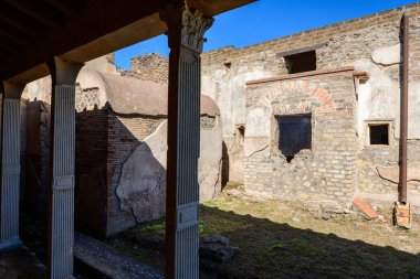 Parlak güneş ışığı, İtalya 'nın Pompeii kentindeki Julia Felix' in evinin flütlü sütunları ve yıpranmış taş duvarları boyunca keskin gölgeler bırakır. Açığa çıkan taş, kemerli pencere ve dokulu yüzeyler antik Roma mimarisinin atmosferini çağrıştırıyor.