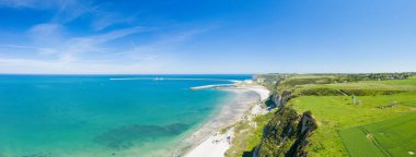 Dramatik yeşil uçurumlar ve açık tarım arazileriyle çevrili, açık mavi gökyüzü ve güneş ışığı Le Havre yakınlarındaki Normandiya kıyılarının dokusunu aydınlatıyor..