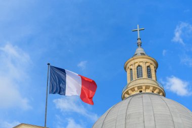 Paris 'teki büyük taş kubbenin ve Pantheon' un çaprazının yanında dalgalanan üç renkli Fransız bayrağı, dağınık bulutlarla dolu canlı mavi bir gökyüzüne çarpıyor..