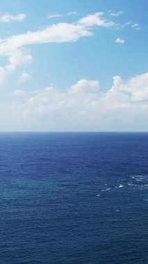 Derin mavi Akdeniz 'in sakin manzarası. Parlak bir gökyüzünün altında, dağınık bulutlarla. Fanale di Petra, Korsika yakınlarında..