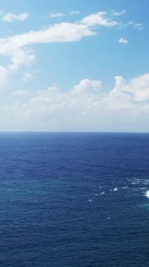 Korsika 'da Fanale di Petra yakınlarında bulutların dağıldığı parlak bir gökyüzünün altındaki derin mavi Akdeniz manzarası. Yumuşak dalgalı sakin deniz manzarası ve berrak ufuk..