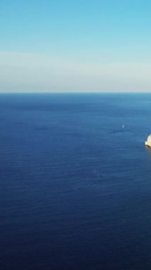 Uzak bir yelkenli ve berrak gökyüzü ile sakin mavi Akdeniz manzarası, Bonifacio, Korsika yakınlarında ele geçirildi..