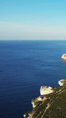 Güneşli bir günde Bonifacio, Korsika kıyıları boyunca dramatik beyaz uçurumlar ve berrak mavi deniz manzarası..