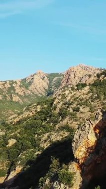 Fransa 'nın Korsika kentindeki Calanques de Piana kıyı şeridi boyunca uzanan engebeli uçurumların ve mavi denizin manzarası.