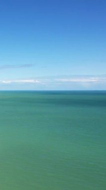 Sword Beach, Hermanville-sur-Mer, Normandiya, Fransa 'da berrak mavi gökyüzü ve durgun turkuaz su.
