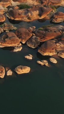 Champassak, Laos 'taki Mekong Nehri boyunca eşsiz kaya oluşumlarının havadan görüntüsü. Doğal ortamda sakin su, yıpranmış taşları sarar..