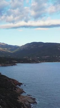 Kıyı şeridinin manzarası ve Cargese, Korsika yakınlarındaki dağların dramatik bulutları ve mavi denizi. Doğal Akdeniz manzarası seyahat ve doğa kavramları için idealdir..