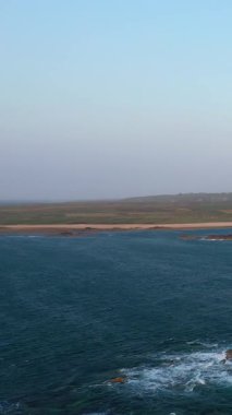 Cap de la Hague, Normandiya, Fransa 'daki engebeli kıyı şeridi ve mavi deniz manzarası açık bir gökyüzünün altında..