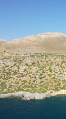 Girit 'te, Plage de Preveli kıyısındaki kayalık tepelerin ve berrak mavi denizin geniş manzarası..