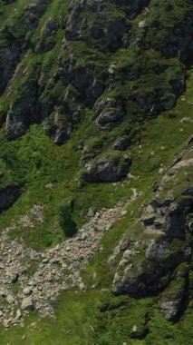 Cascade Le Hecou yakınlarında yemyeşil bitki örtüsüyle kaplı engebeli, kayalık bir dağ. Kaya ve dik yamaçlı doğal manzara..