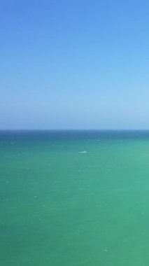 Normandiya, Cap de la Hague yakınlarında yakalanan turkuaz suların berrak mavi gökyüzü ile buluşması. Sakin atmosferli minimalist deniz manzarası.