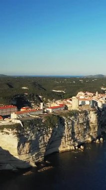 Bonifacio 'nun hava manzarası Fransa' nın Korsika kentindeki denize bakan dramatik beyaz kireçtaşı uçurumlarına tünemişti. Tarihi kasabada açık mavi gökyüzü altında kırmızı çatılı binalar ve çarpıcı kıyı manzarası yer alıyor..