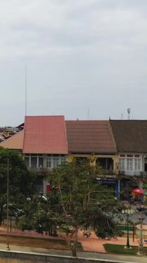 Bulutlu bir günde geleneksel çatı manzarası ve şehir merkezindeki Battambang, Kamboçya 'da küçük bir park alanı.