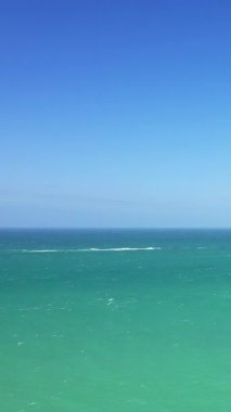 Açık mavi gökyüzünün altında canlı turkuaz sular, Normandiya 'nın Cap de la Hague sahilinde ele geçirildi. Minimalist deniz manzarası arka plan ve yaratıcı projeler için idealdir.