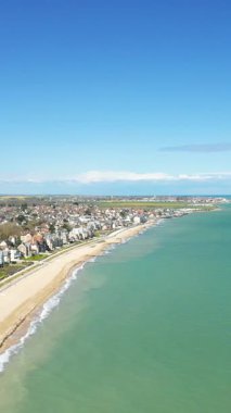 Sword Beach 'in manzaralı manzarası ve Normandiya, Fransa' daki Hermanville-sur-Mer kıyı kasabası, turkuaz deniz ve açık mavi gökyüzü..