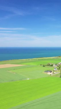 Bereketli yeşil tarlalar ve dramatik Normandiya uçurumlarına ve açık gökyüzünün altındaki mavi denize doğru uzanan tarım arazileri. Sahil ufku olan sakin kırsal alan..