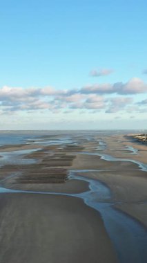Geniş kum, gelgit havuzları ve dramatik bir gökyüzünün yer aldığı Normandiya, Fransa 'daki Utah Sahili' nin havadan görünüşü. Huzurlu manzara yumuşak doğal ışıkla yıkanır..