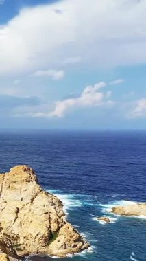 Korsika 'daki Fanale di Petra' da, parlak mavi bir gökyüzünün altında dalgaların kıyıya vurduğu dramatik kayalık kıyı şeridi. Manzara deniz manzarası seyahat ve doğa kavramları için mükemmeldir..