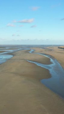 Utah Beach, Normandiya 'da gelgit havuzları ve mavi gökyüzü olan geniş kumlu bir sahil. Sakin kıyı manzarası seyahat ve doğa kavramları için idealdir..