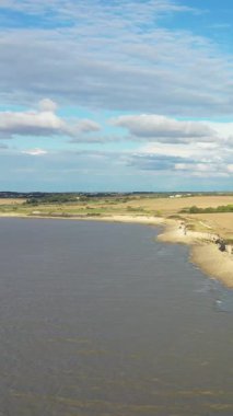 Nazik uçurumları ve bulutlu bir gökyüzünün altında açık arazileri olan sakin bir kırsal nehir manzarası. Huzurlu doğal manzara kırsal ve huzur kavramları için idealdir..