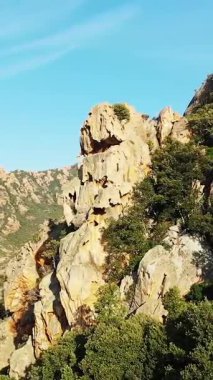 Fransa 'nın Korsika kentindeki Calanques de Piana' daki kayalık kayalıkların ve yemyeşil bitki örtüsünün açık mavi gökyüzünün altındaki hava manzarası..