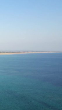Sade mavi denizin ve kumlu kıyı şeridinin havadan görünüşü Grande Plage de Barneville, Normandiya, Fransa 'da berrak bir gökyüzünün altında.