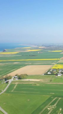 Fransa 'nın Normandiya kenti Longues-sur-Mer yakınlarındaki arazi ve sahil manzaralı açık mavi gökyüzü altında.