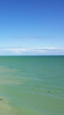 Sword Beach, Lion-sur-Mer, Normandiya 'da berrak mavi gökyüzü ve yumuşak dalgalarla sakin bir deniz manzarası. Huzurlu sahil manzarası seyahat ve rahatlama kavramları için idealdir.