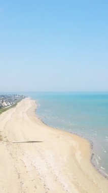 Normandiya, Fransa 'daki Utah Sahili' nin geniş kumlu kıyı şeridi sakin turkuaz deniz ve açık mavi gökyüzü güneşli bir günde.