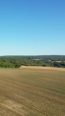 Fransa 'nın Cuncy les Varzy şehrinde açık mavi gökyüzünün altında tarım arazileri ve yeşil ormanlar geniş bir görüş alanına sahiptir. Yazın sonlarında sakin kırsal alan.