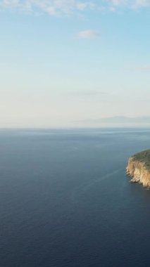 Yunanistan 'ın Mani bölgesindeki Diros Sahili yakınlarındaki engebeli uçurumlar ve derin mavi deniz manzarası. Temiz gökyüzü ve sakin sular huzurlu bir Akdeniz manzarası yaratır..