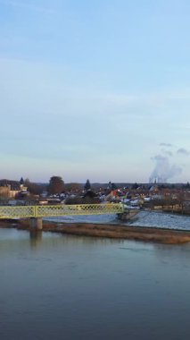 Tarihi Sully-sur-Loire kalesi, metal bir köprü ve şehri kaplayan hafif karlı Loire Nehri 'nin yer aldığı manzaralı bir kış manzarası. Açık bir günde Sully-sur-Loire, Fransa 'da yakalandı.