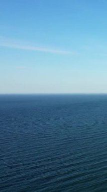 Normandiya kıyılarından yakalanan açık mavi gökyüzünün altında sakin bir deniz manzarası. Yaratıcı projeler için barışçıl ve minimalist deniz manzarası ideal.