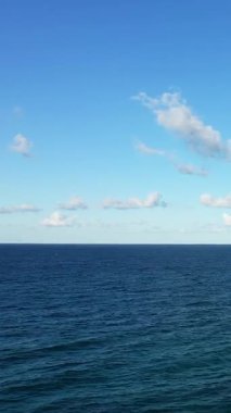 Berrak mavi bir gökyüzünün altında, Brindisi, İtalya yakınlarında dağınık bulutların ele geçirdiği sakin bir deniz manzarası. Huzur, seyahat ve doğa kavramları için mükemmel..