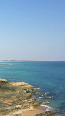Cap de Carteret 'teki kayalık kıyı şeridi ve kumlu plaj manzarası, berrak mavi gökyüzü ve sakin deniz. Seyahat, doğa ve kıyı temaları için ideal.