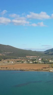 Kilada köyünün manzarası. Parlak bir gökyüzü altında tarlaları, tepeleri ve sakin mavi suları var. Yunanistan 'ın huzurlu kırsal manzarası.