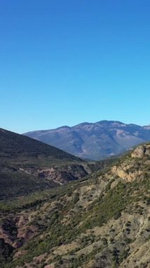 Yunanistan 'ın Osios Loukas Manastırı yakınlarındaki açık mavi gökyüzü altında engebeli dağlar ve tepelerin manzarası.