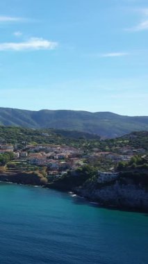 İtalya 'nın Palinuro kentindeki sahil ve yamaçların manzarası turkuaz deniz ve açık mavi gökyüzünün altındaki yemyeşil tepeler..